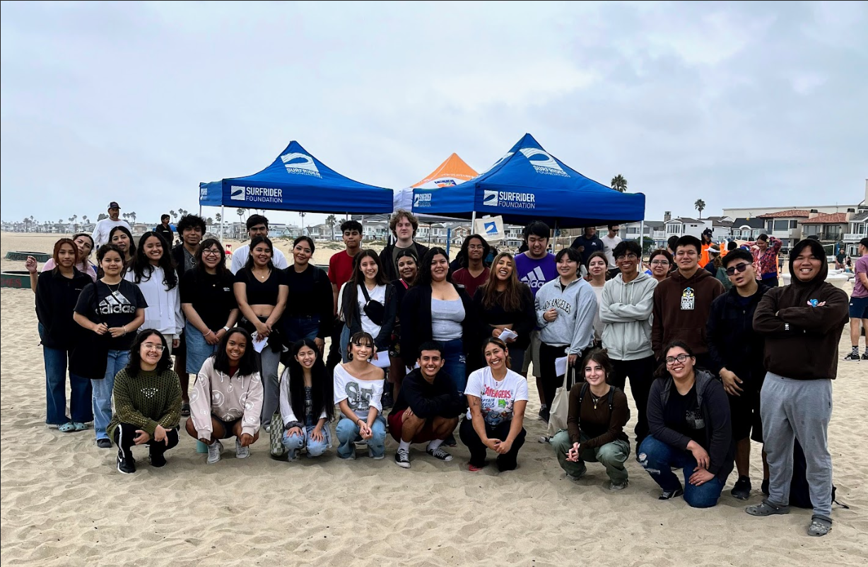 SAC ULink students pose on the base for the Surfrider Foundation beach clean-up volunteer event.